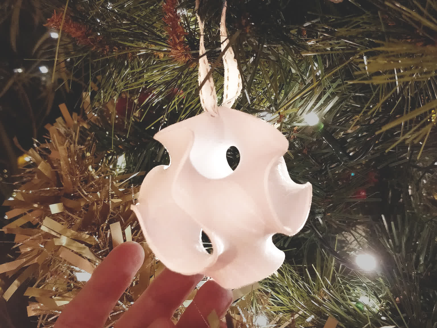 A gyroid christmas ornament on a tree