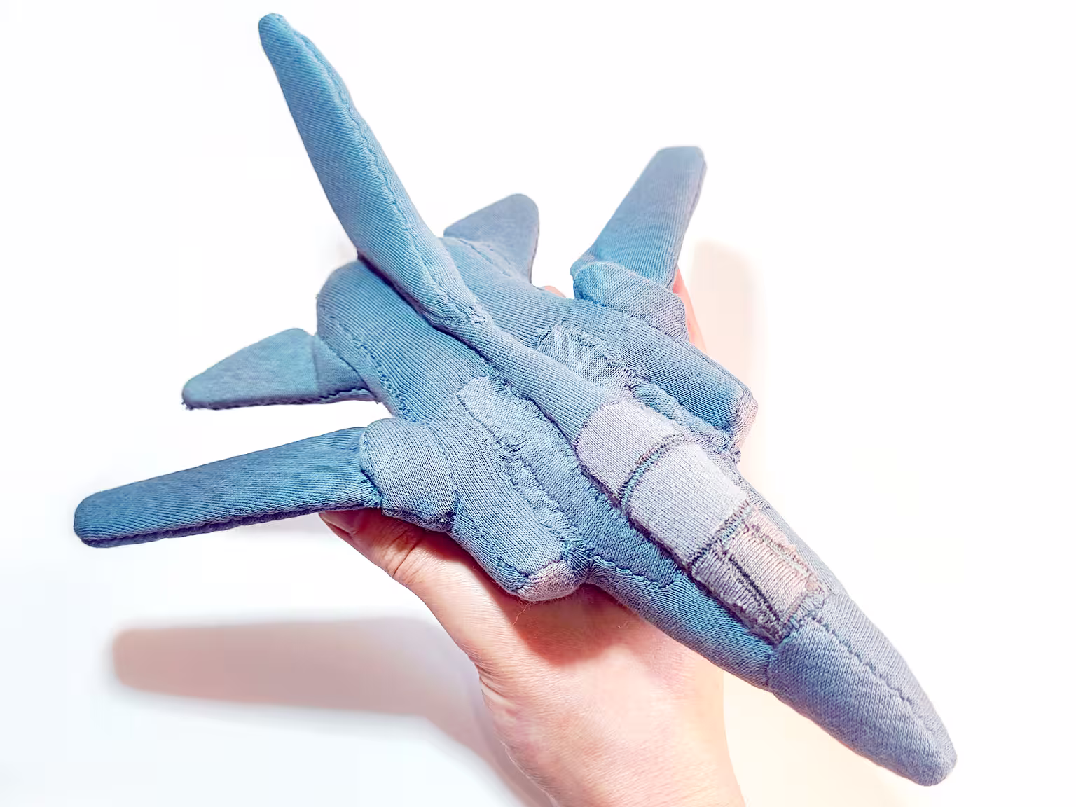 Soft toy fighter jet held in a hand
